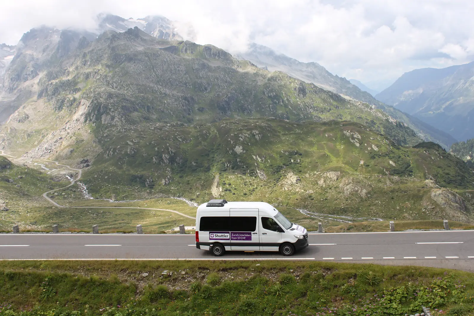 A Shuttler minibus on an alpine mountain road